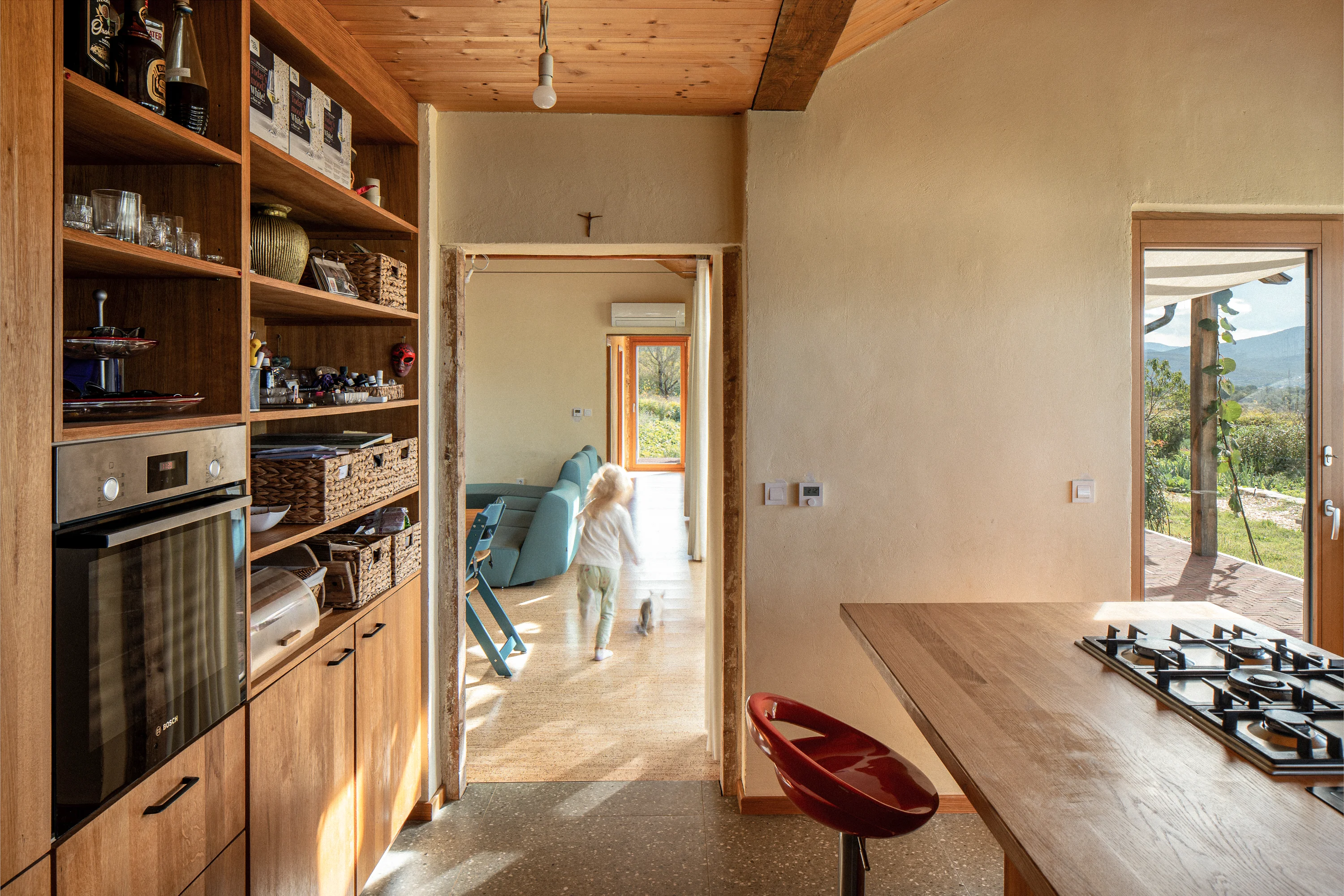 Inside the hempcrete home, kitchen, light, a child running